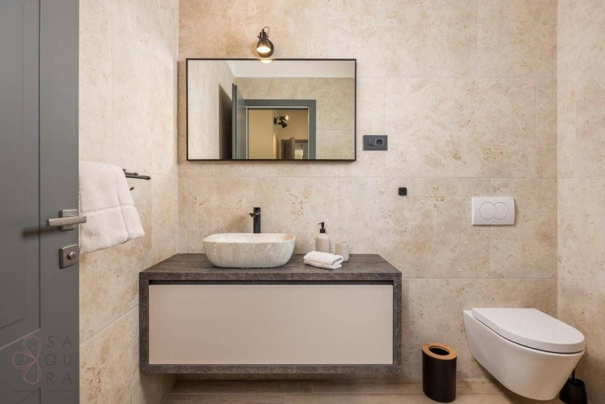 Zeitgemäßes Badezimmer mit schwebendem Waschtisch, Aufsatzwaschbecken und wandhängendem WC.