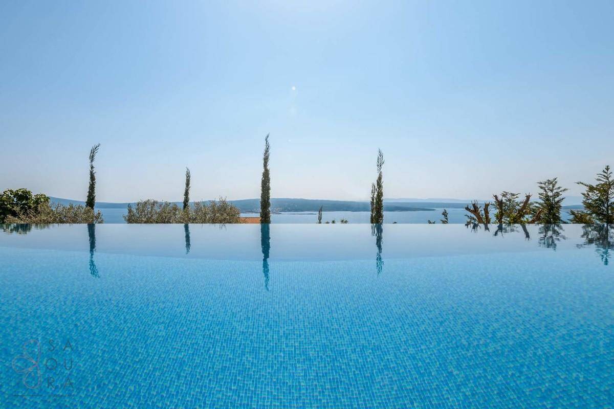 Atemberaubender Infinity-Pool mit weitem Blick über das glitzernde Meer und den Horizont.