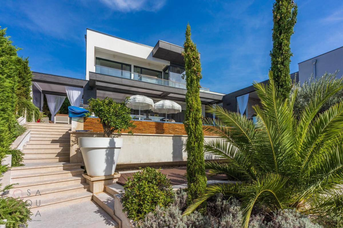 Moderne Villa mit gestuftem Garten, Poolbereich und mediterraner Bepflanzung.