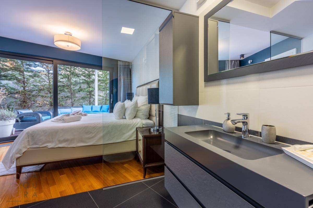 Modernes Badezimmer mit stilvollem Waschbecken und Blick auf das angrenzende Schlafzimmer.