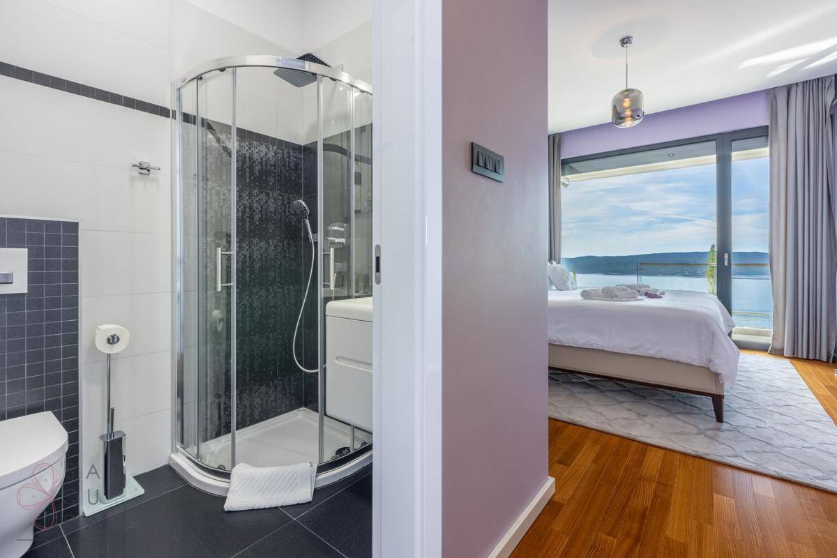 Ansicht eines Badezimmers mit Dusche und eines Schlafzimmers mit Meerblick.
