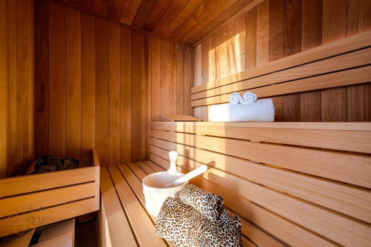 Gemütliche Holzsauna mit Bänken und traditionellem Zubehör für Entspannung.