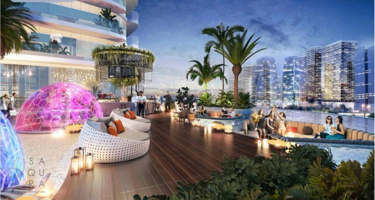 Abendliche Lounge-Terrasse mit stilvollen Sitzgelegenheiten, Palmen und Stadtblick.