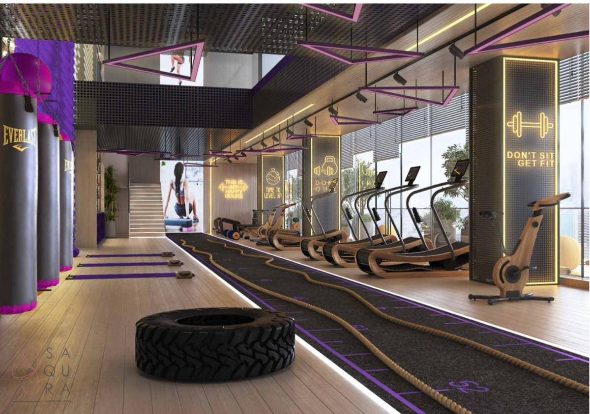 Modernes Fitnessstudio mit vielfältigen Trainingsgeräten, Boxsäcken und Laufbahn.