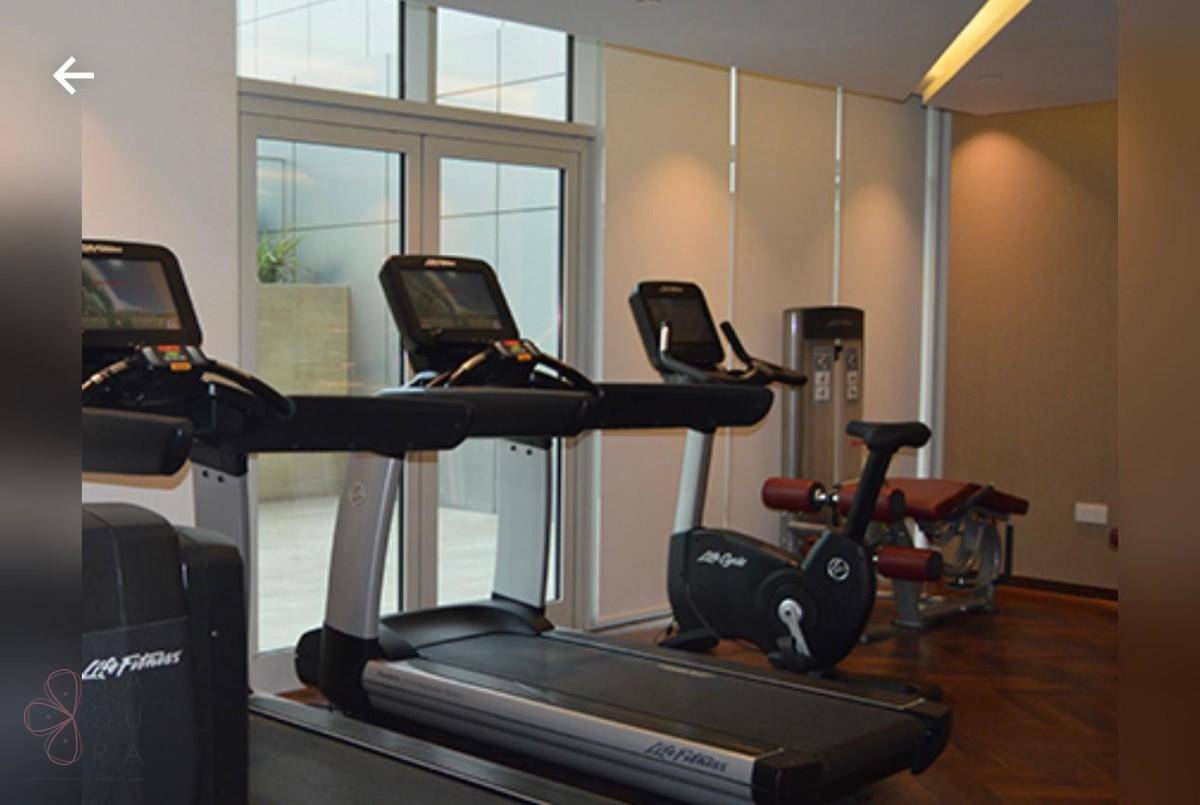 Modernes Fitnessstudio mit Laufbändern, Trainingsgeräten und Holzboden.