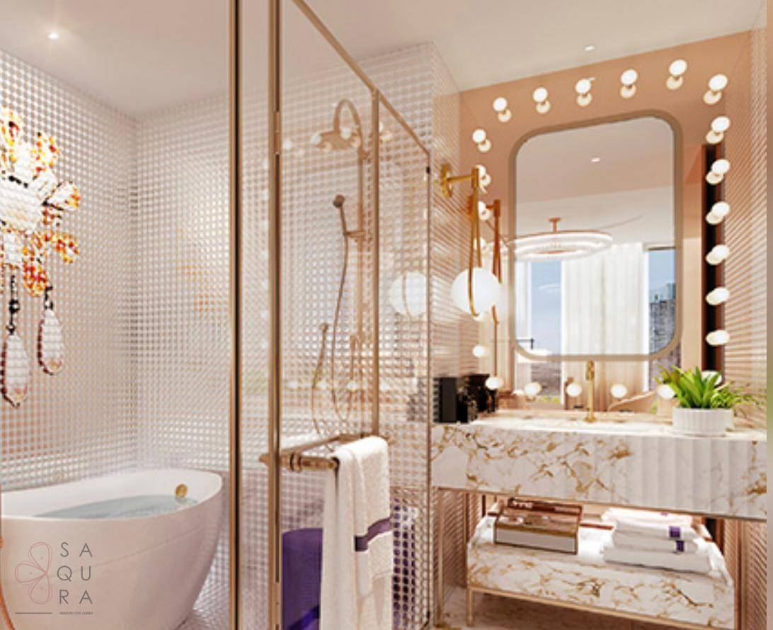 Elegantes Badezimmer mit freistehender Badewanne, Glasdusche und beleuchtetem Spiegel.