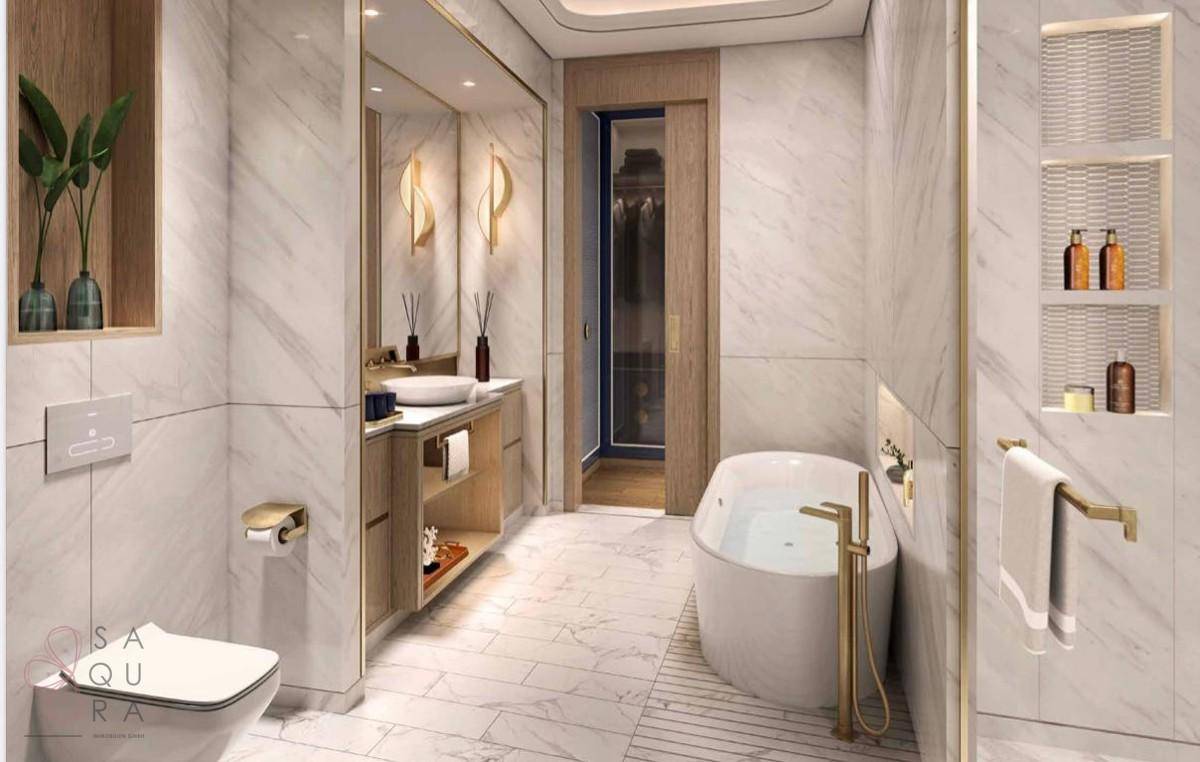 Elegantes Badezimmer mit Marmorfliesen, Badewanne und Zugang zum Ankleidezimmer.