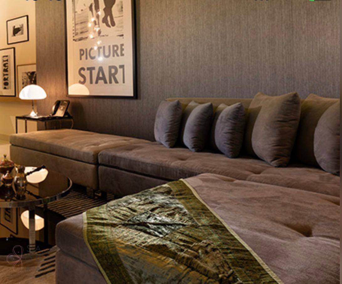 Gemütliches Wohnzimmer mit großem Sofa, dekorativen Kissen und stilvoller Wandgestaltung.