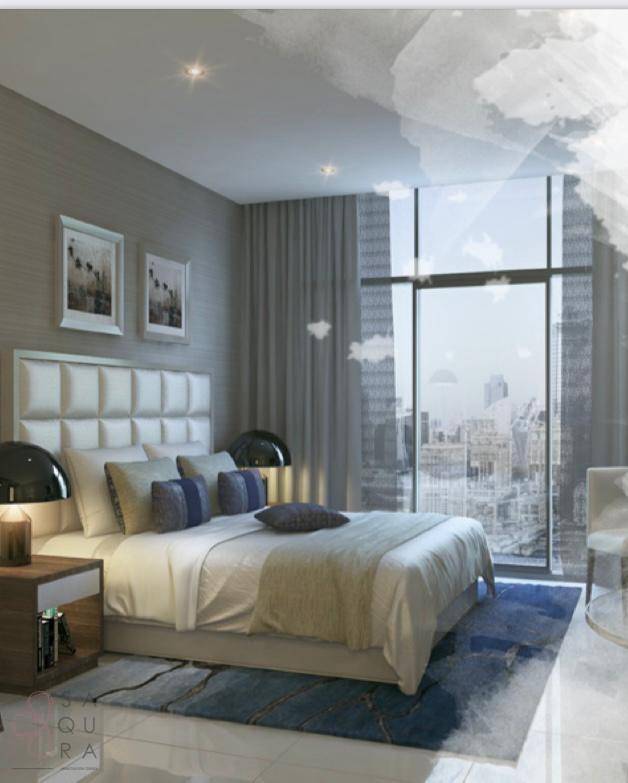Modernes Schlafzimmer mit großem Fenster, Stadtblick und bequemen Möbeln in Grautönen.