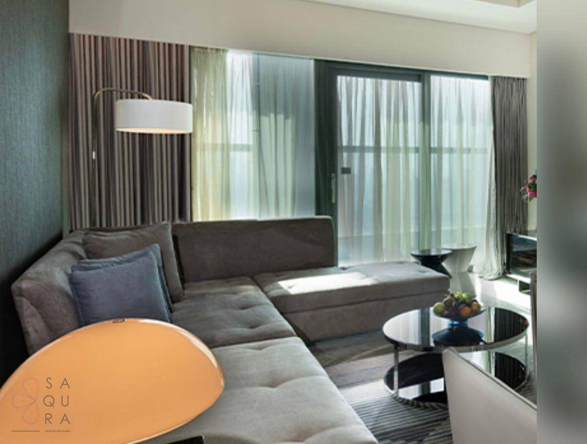 Helles Wohnzimmer mit großem Ecksofa, modernen Vorhängen und Zugang zu einem Balkon.