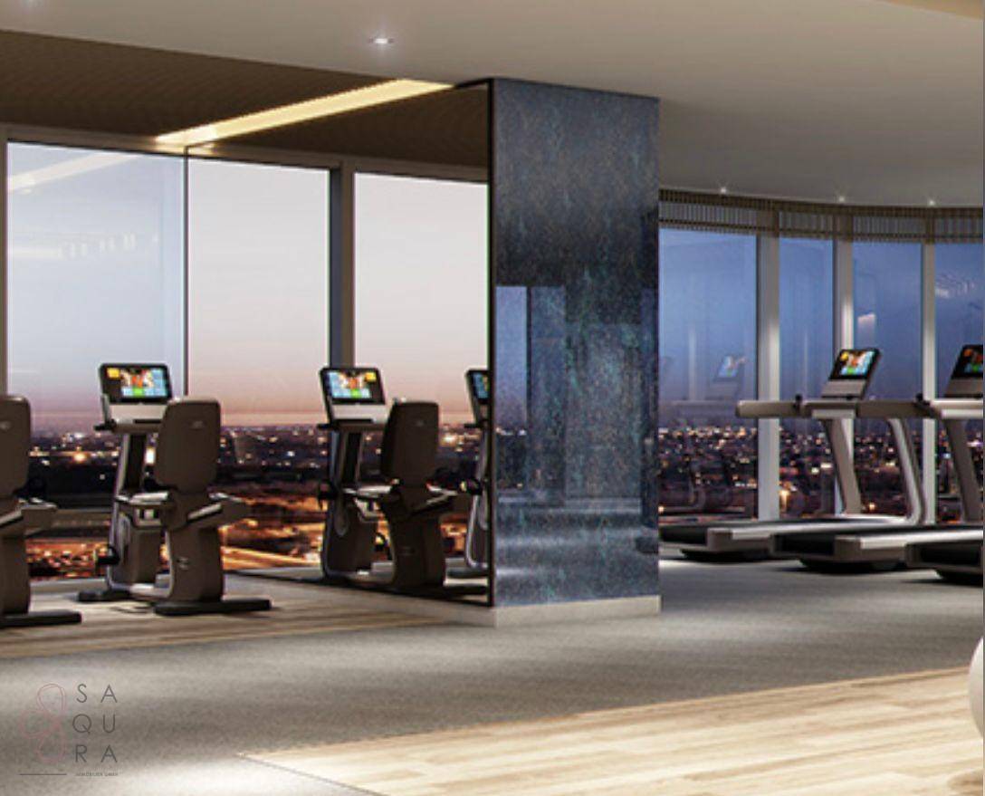 Modernes Fitnessstudio mit Trainingsgeräten und Panoramafenstern mit Blick auf die Stadt.