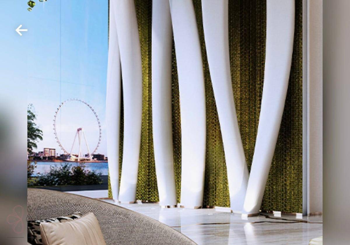 Heller Innenraum mit großen Fenstern und Blick auf das Riesenrad und die Wasserfront.