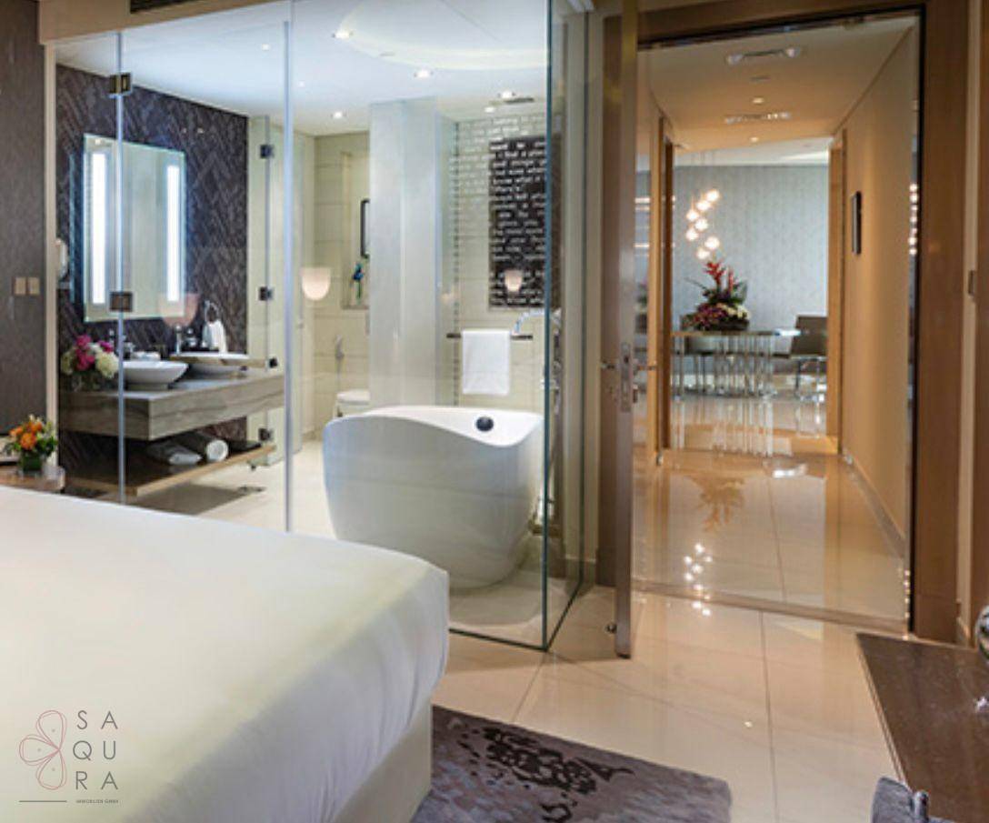 Schlafzimmer mit offenem Zugang zu einem luxuriösen Badezimmer mit freistehender Badewanne.