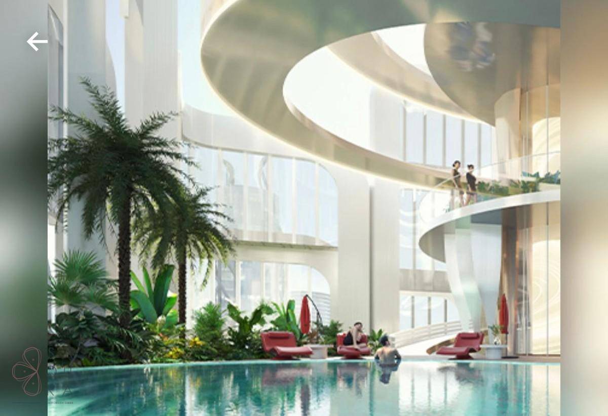 Luxuriöser Innenpoolbereich mit Palmen, Liegestühlen und entspannter Atmosphäre.