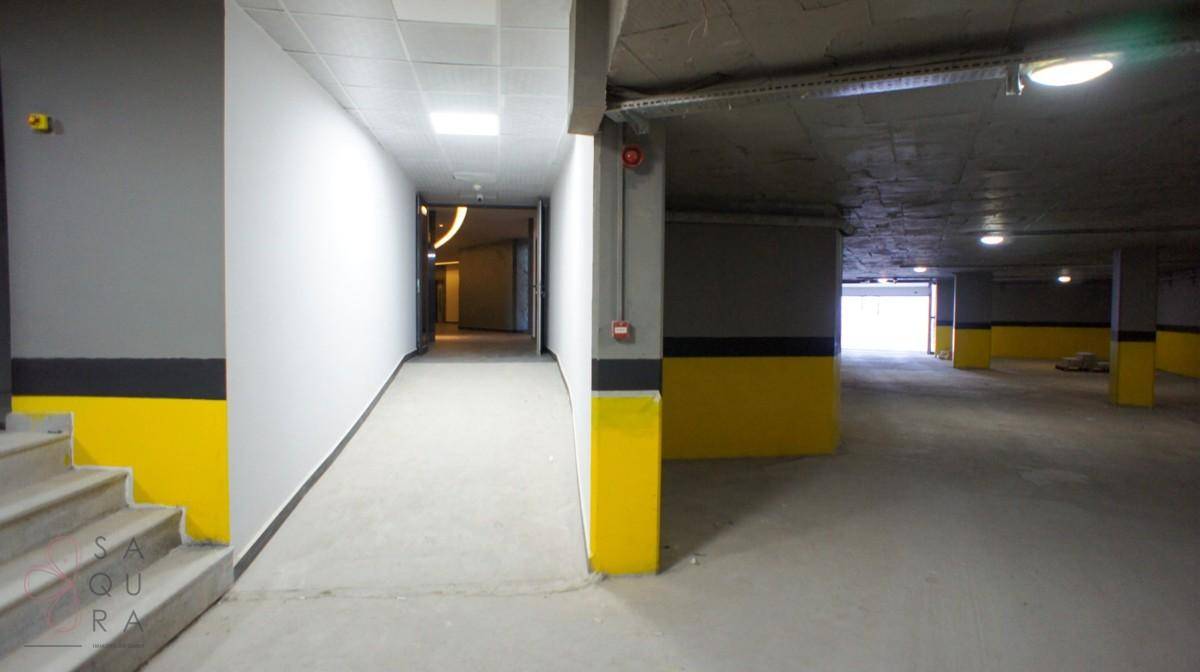 Geräumige Tiefgarage mit Rampe, gelben Markierungen und Betonwänden für sicheres Parken.