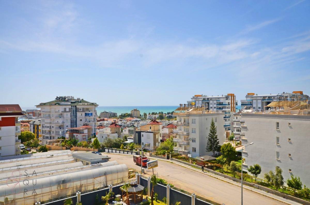 Panoramablick auf die Stadt mit Gebäuden, Straße und dem Meer in der Ferne.
