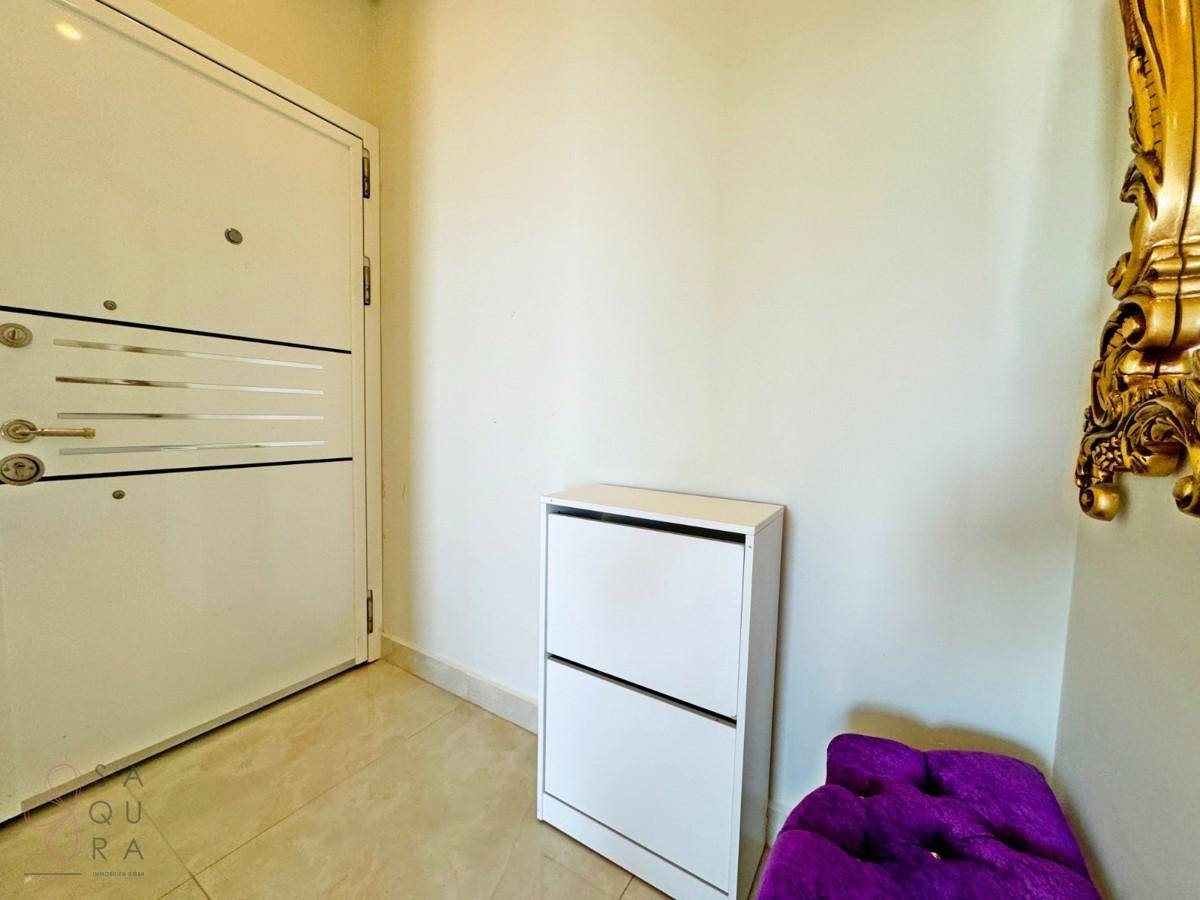 Eingangsbereich mit Sicherheitstür, Schuhschrank und Blick auf einen dekorativen Spiegel.