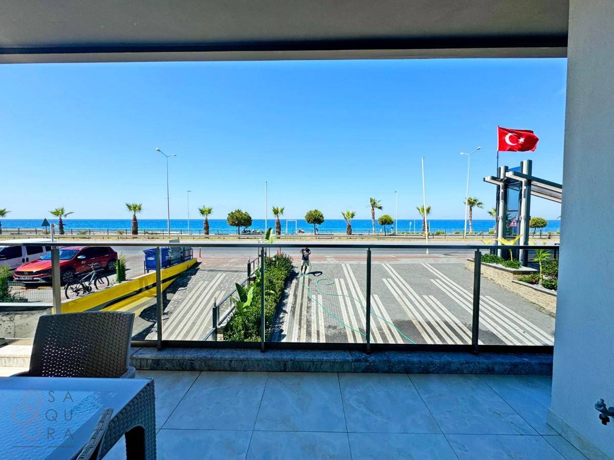 Balkon mit Meerblick, ausgestattet mit Outdoor-Möbeln und Blick auf die Küstenstraße.