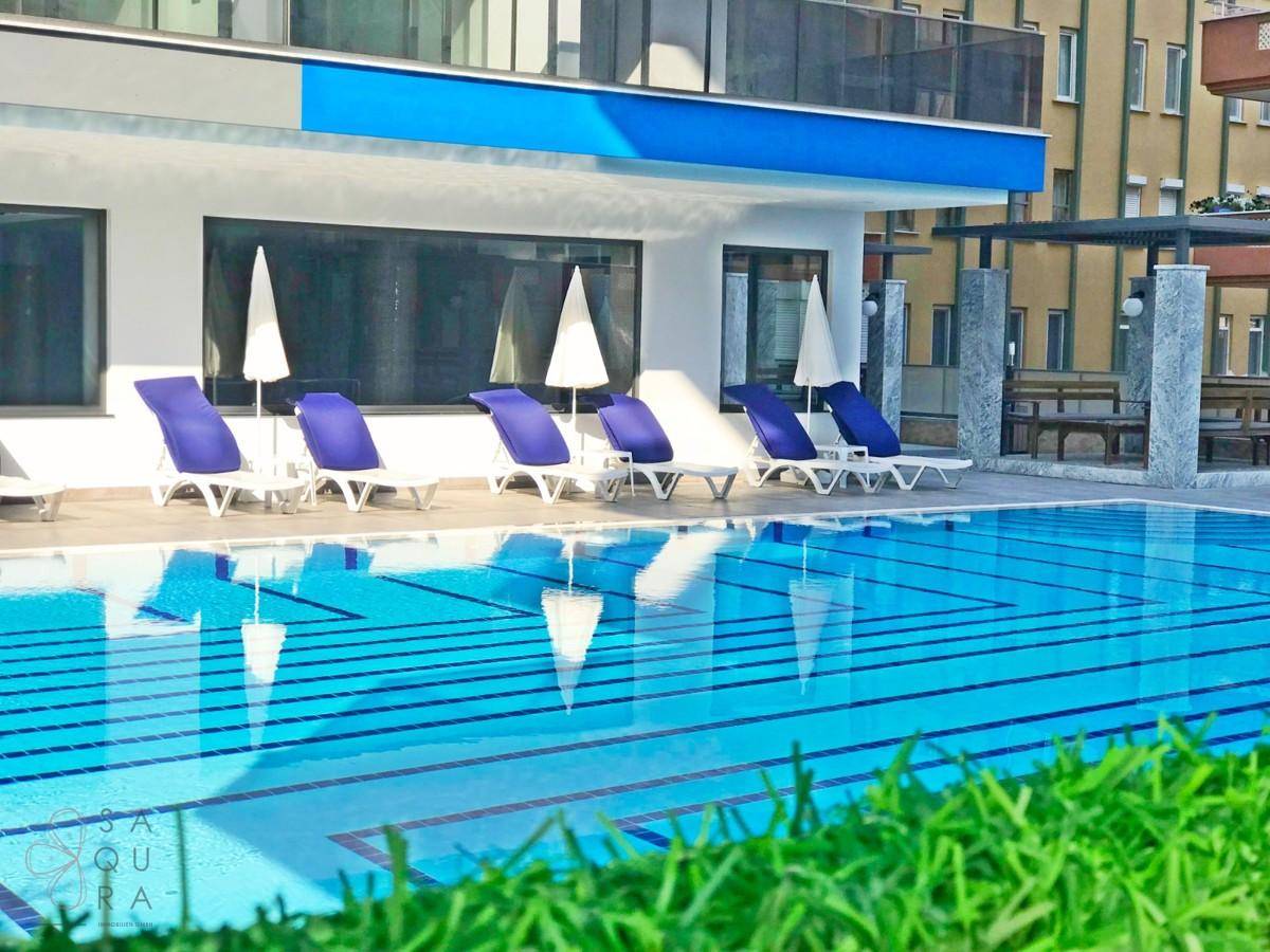 Außenpoolbereich mit Sonnenliegen und Sonnenschirmen, ideal zum Entspannen.