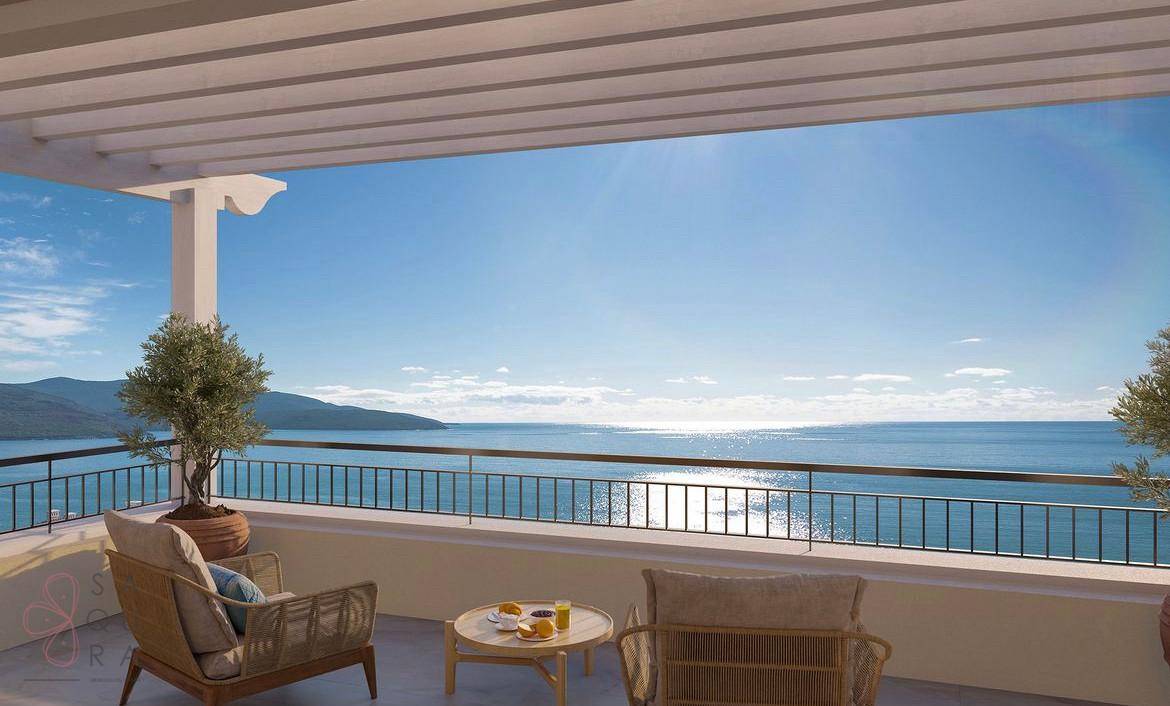 Geräumige Terrasse mit Sitzgelegenheiten und weitem Blick auf das Meer unter einer Pergola.