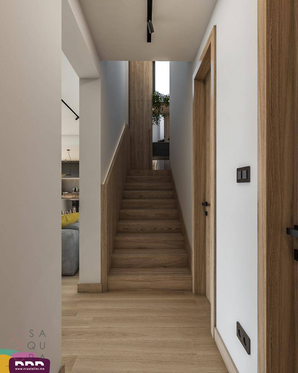 Heller Flur mit Holzboden und Blick auf eine Holztreppe.
