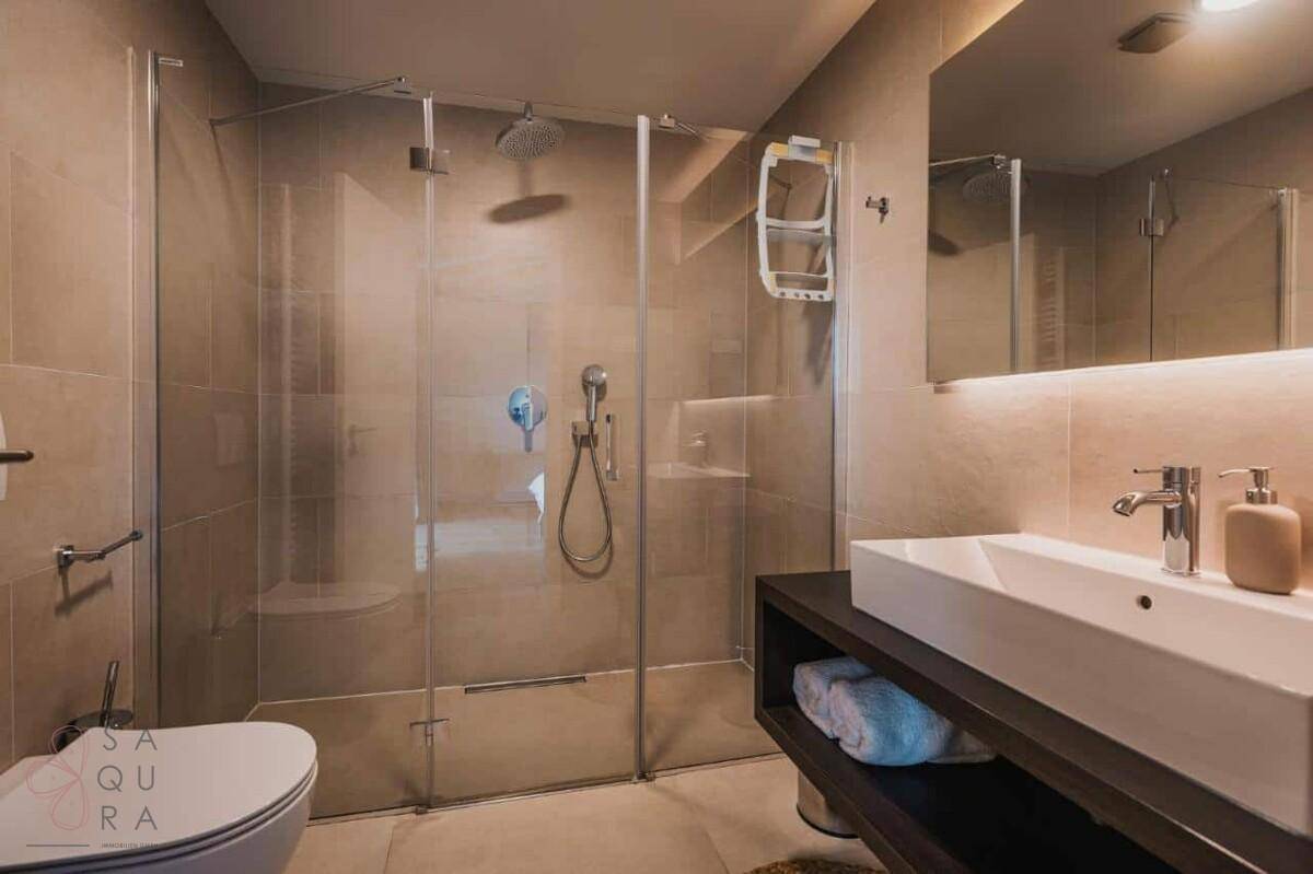 Modernes Badezimmer mit begehbarer Dusche, elegantem Waschtisch und Wand-WC.