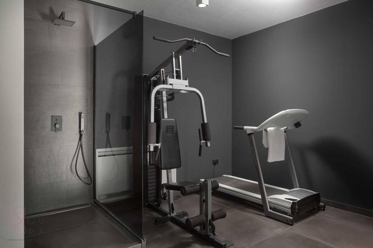 Privater Fitnessraum mit Laufband und Krafttrainingsgerät in modernem Ambiente.