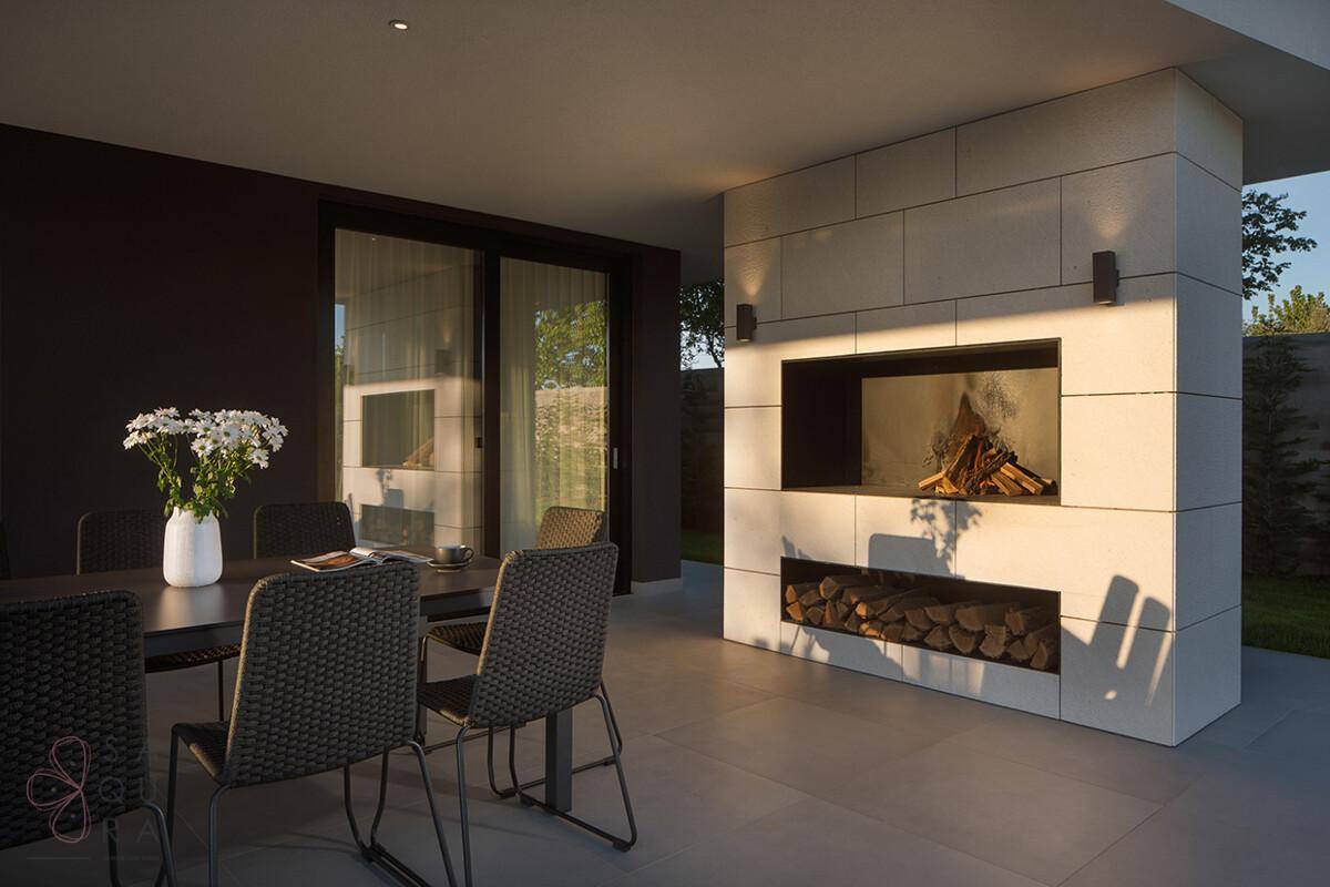 Moderne Terrasse mit Essbereich und integriertem Außenkamin, ideal für gesellige Abende im Freien.