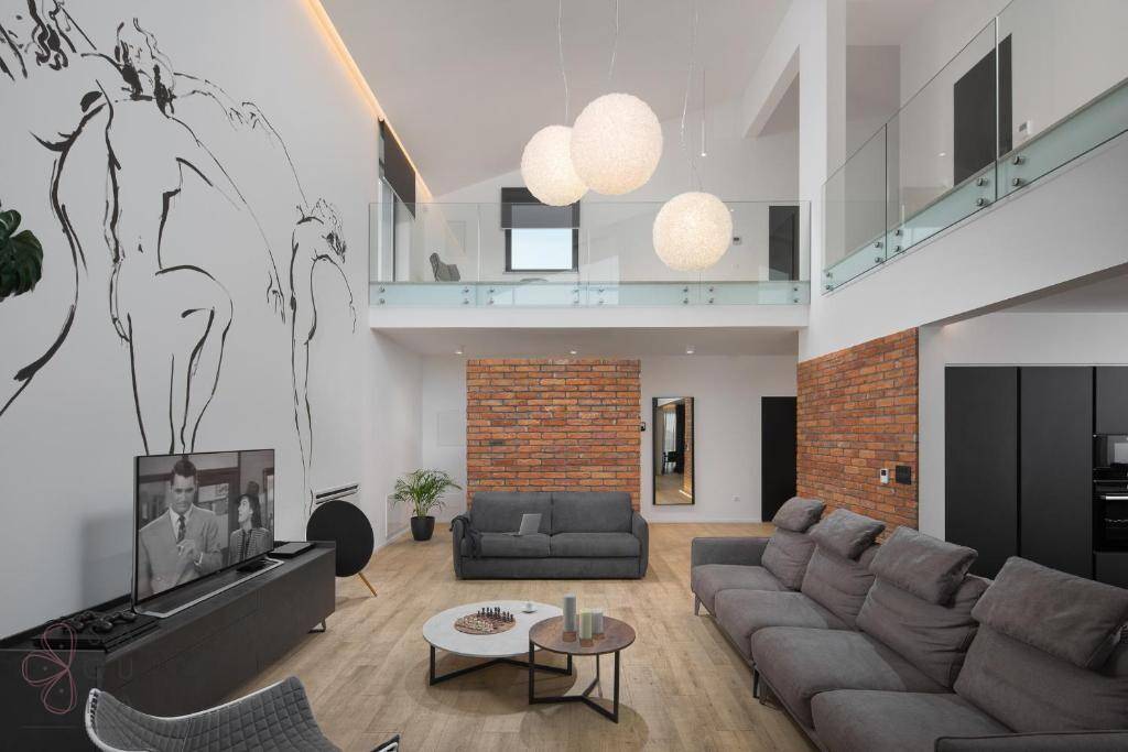 Großzügiges Wohnzimmer mit hohen Decken, moderner Kunst an der Wand und offener Galerie.