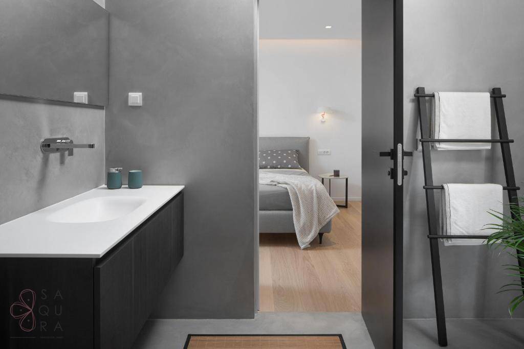 Modernes Badezimmer mit Waschtisch und Blick in ein angrenzendes Schlafzimmer.