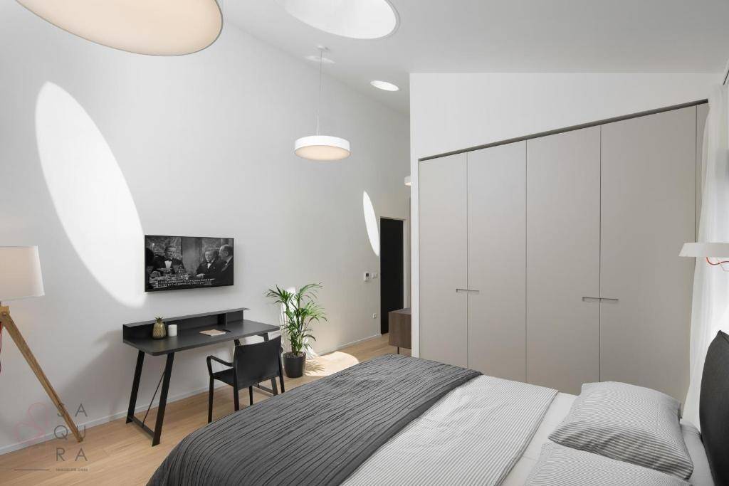 Modernes Schlafzimmer mit integrierten Kleiderschränken, Schreibtisch und indirekter Beleuchtung.