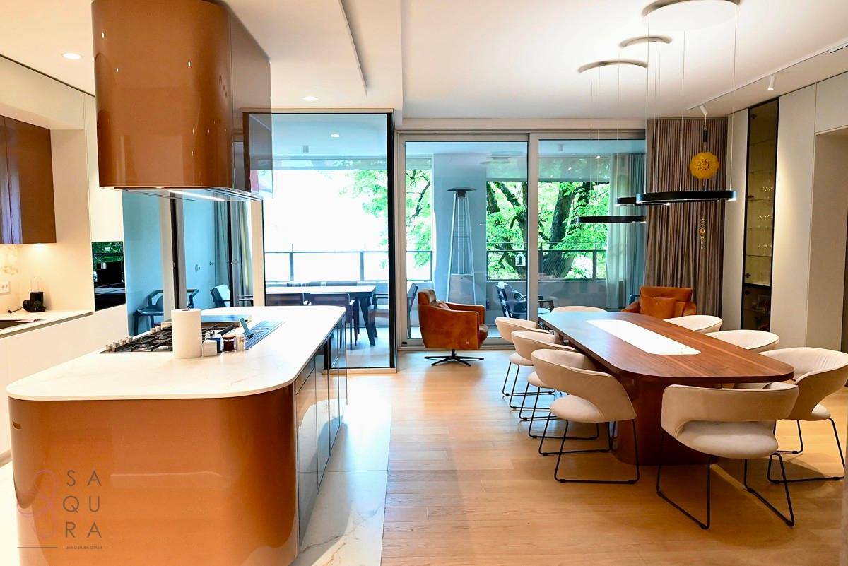Moderne offene Küche mit Kücheninsel und Essbereich, mit Zugang zum Balkon.