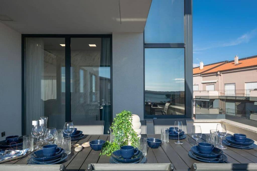Gedeckter Esstisch auf der Terrasse mit Meerblick und blauer Dekoration.