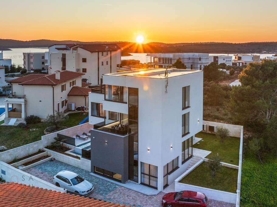 Beeindruckende Villa bei Sonnenuntergang mit Meerblick und umliegender Landschaft.