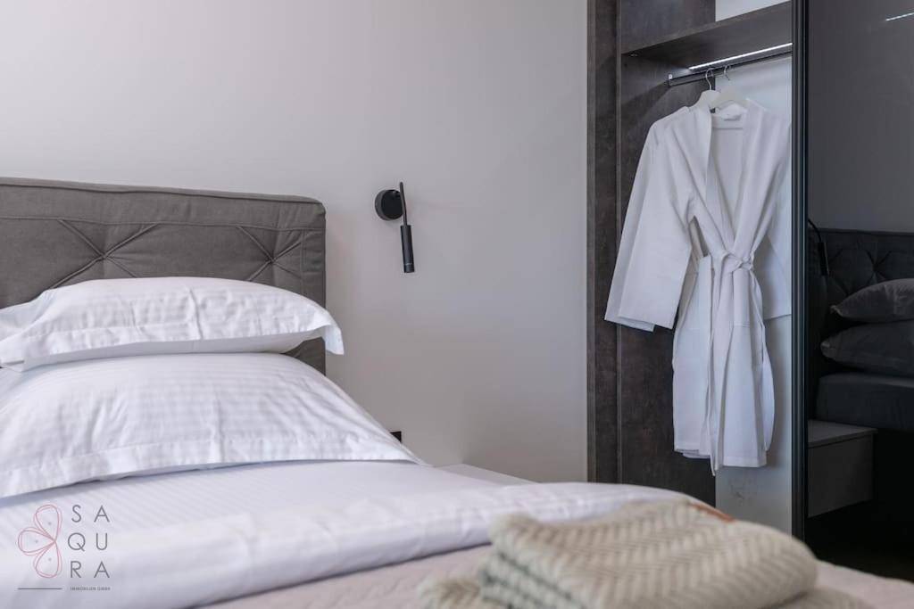 Detailansicht des Bettes und des offenen Kleiderschranks mit Bademantel im Schlafzimmer.