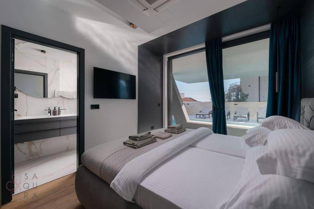 Helles Schlafzimmer mit großen Fenstern, die den Blick auf den Pool und die Landschaft freigeben.