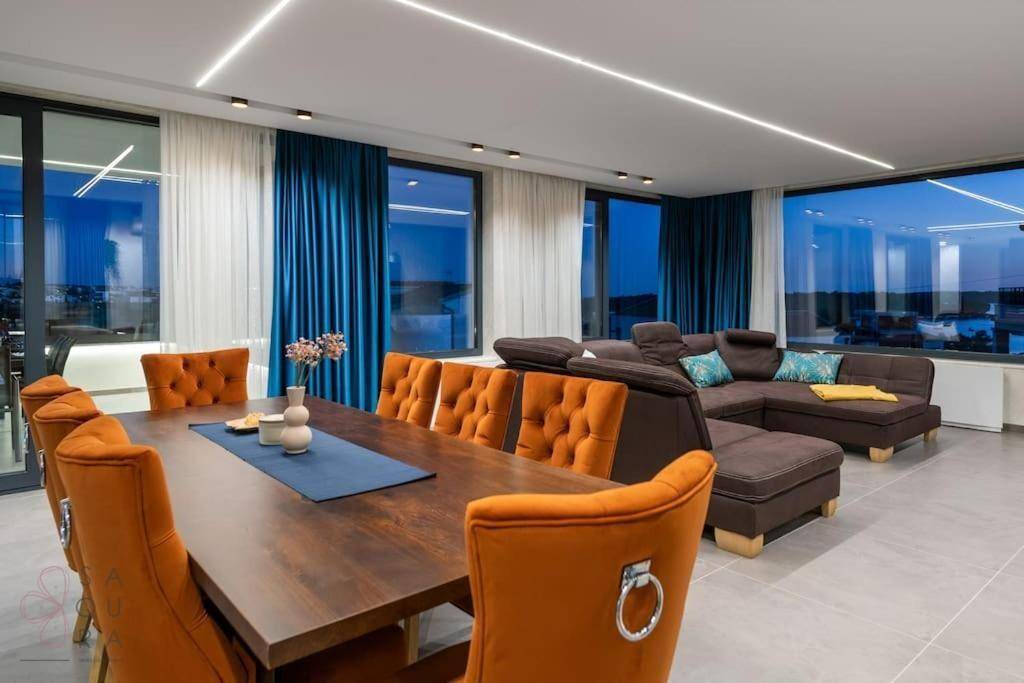 Lichtdurchfluteter Wohn-Essbereich mit Meerblick, bequemer Couch und elegantem Esstisch.