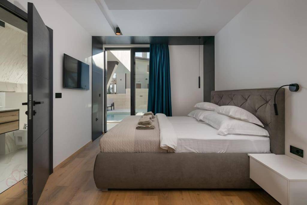 Helles Schlafzimmer mit Zugang zu einem Außenbereich und Blick auf ein angrenzendes Badezimmer.