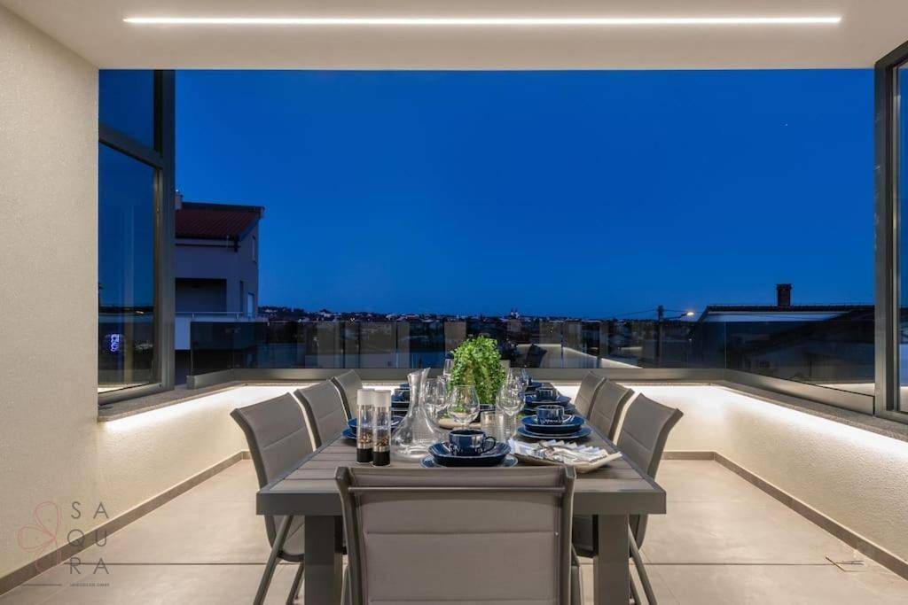 Stilvoller Essbereich auf der Terrasse bei Nacht mit indirekter Beleuchtung und Stadtblick.
