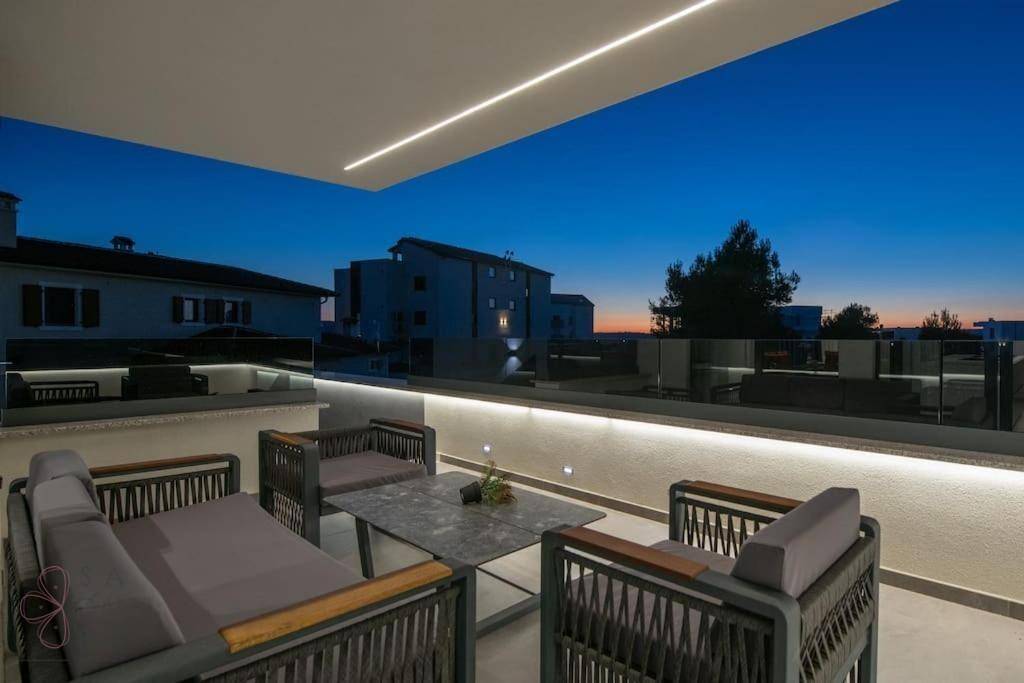 Gemütlicher Lounge-Bereich auf der Terrasse bei Nacht mit stimmungsvoller Beleuchtung.