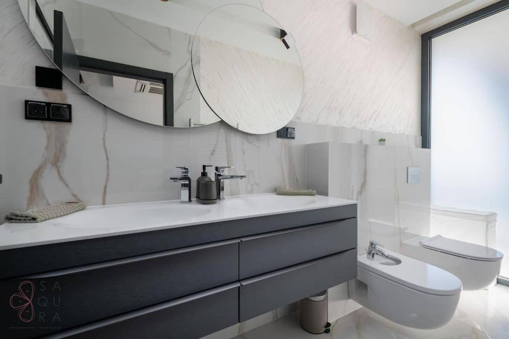 Elegantes Badezimmer mit Marmoroberflächen, schwebendem Waschtisch, wandhängendem WC und Bidet.