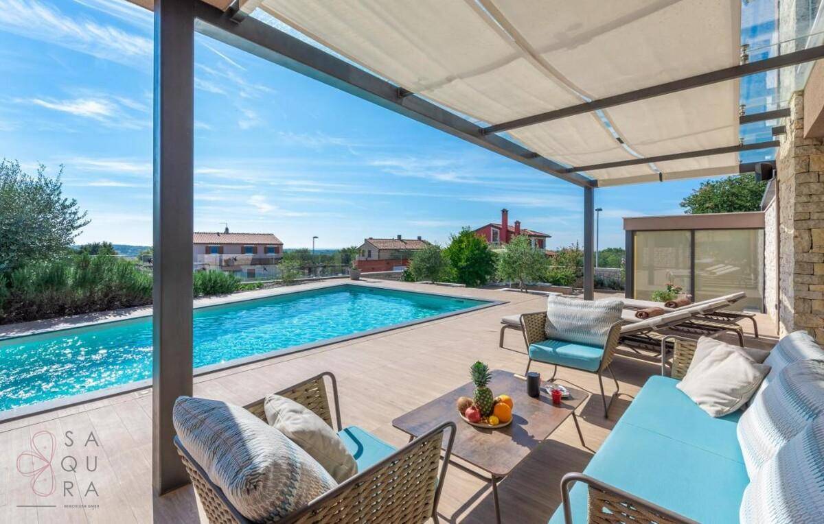 Entspannende Terrasse mit bequemen Lounge-Möbeln und weitem Blick über den Poolbereich.