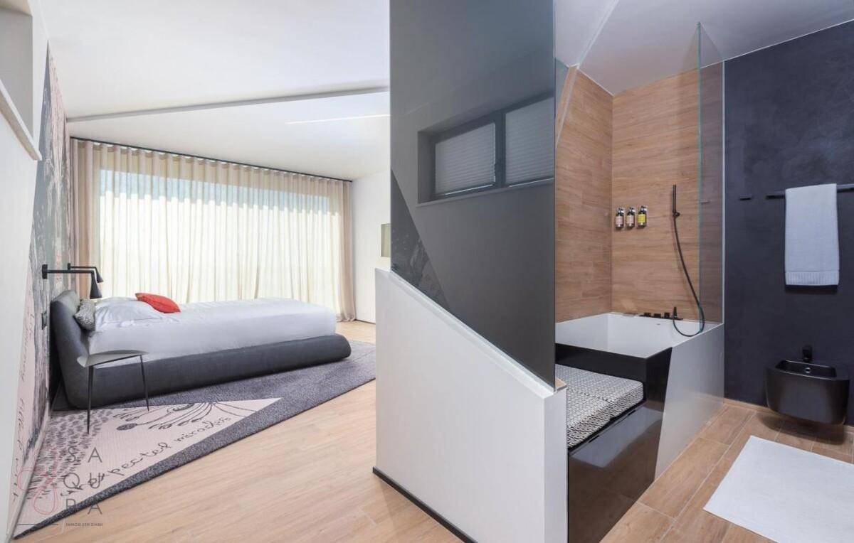 Geräumiges Schlafzimmer mit großem Bett und offenem Zugang zu einem modernen Badezimmer.
