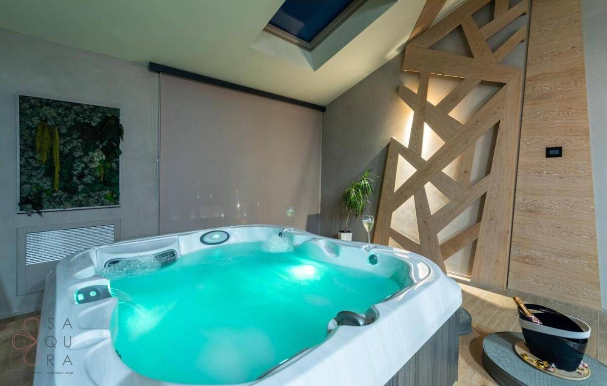Entspannungsbereich mit beleuchtetem Whirlpool und modernem Design, ideal für Abendstunden.