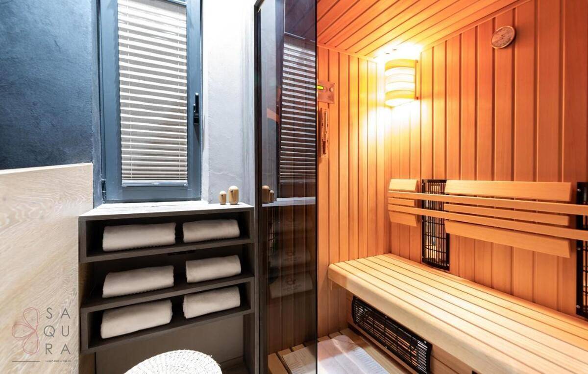 Detailansicht der Holzsauna mit bequemen Bänken und stimmungsvoller Beleuchtung.