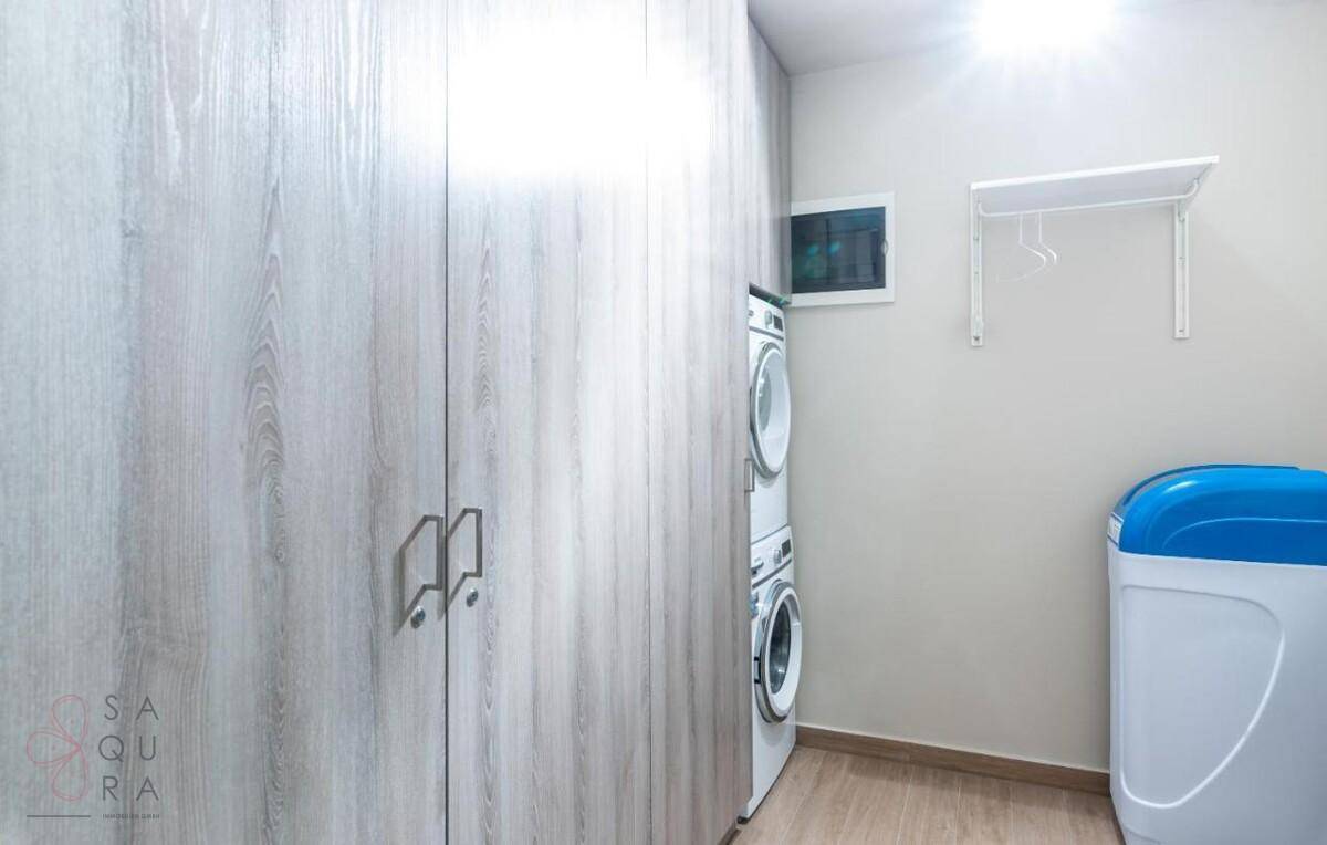 Praktischer Hauswirtschaftsraum mit Waschmaschine, Trockner und viel Stauraum.
