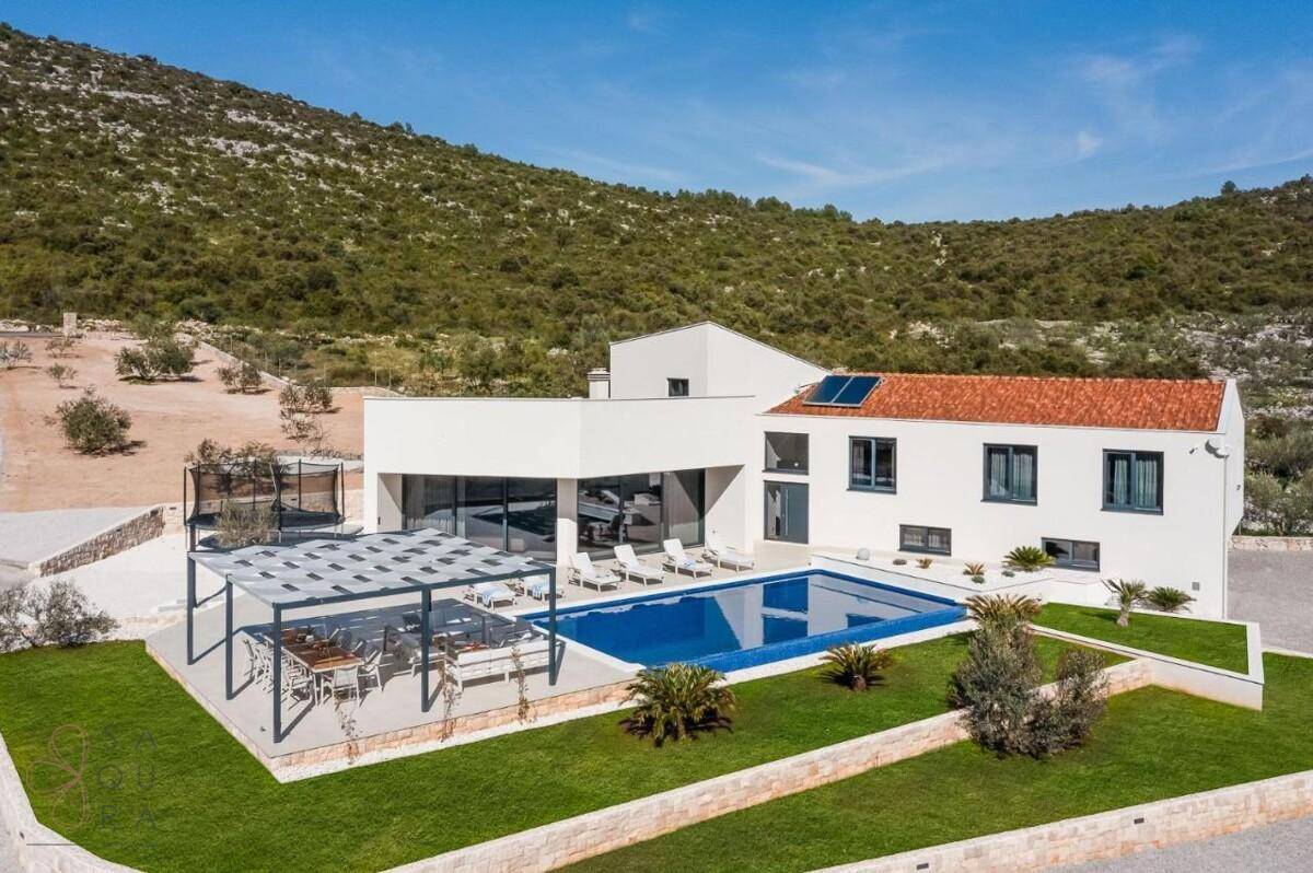Luftaufnahme der modernen Villa mit Pool, Pergola und weitem Blick auf die hügelige Landschaft.