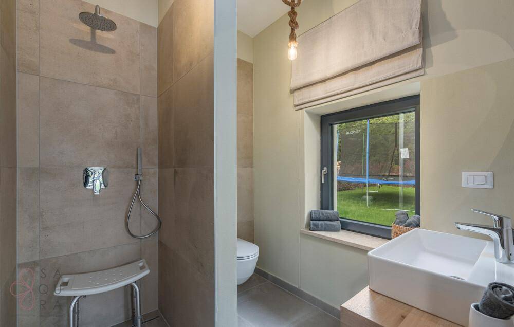 Modernes Badezimmer mit begehbarer Dusche, Einzelwaschbecken und Fenster mit Gartenblick.