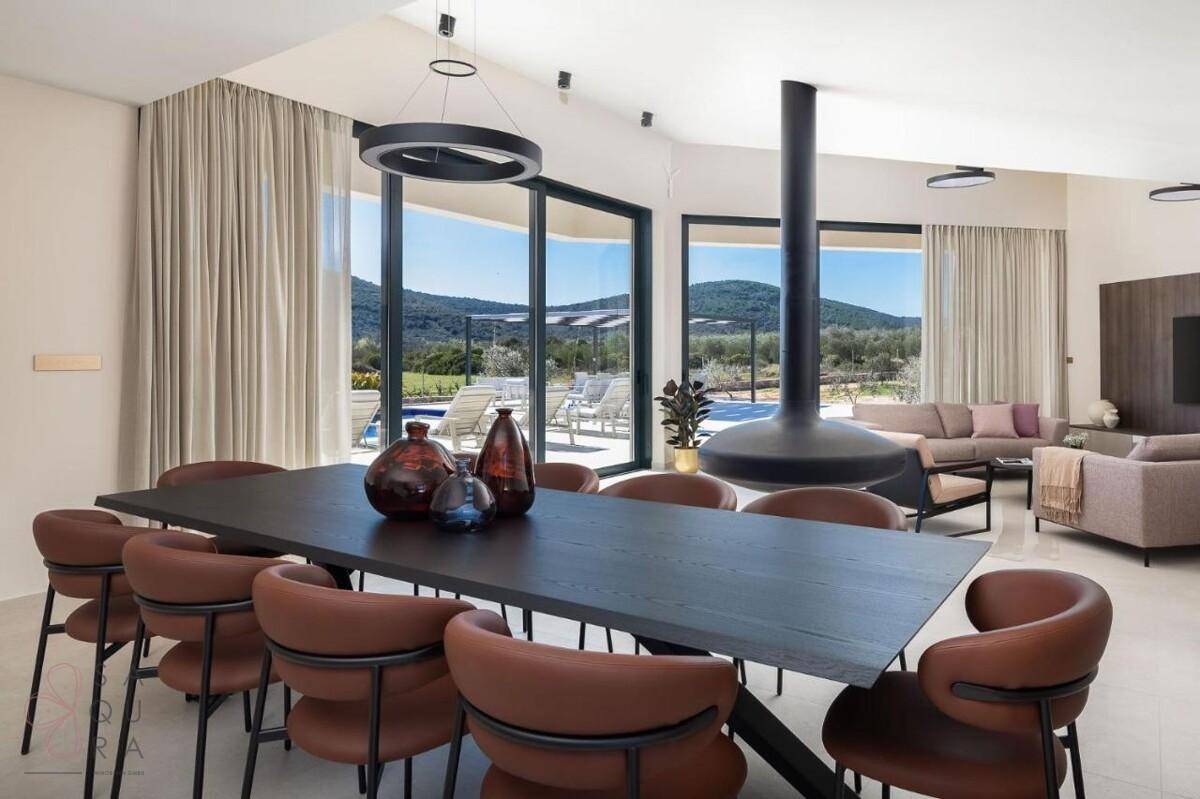 Geräumiger Wohn-Essbereich mit modernem Hängekamin, großem Esstisch und Zugang zur Terrasse.