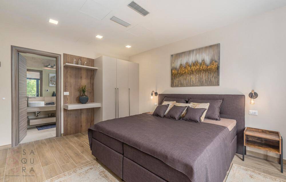 Geräumiges Schlafzimmer mit großem Bett, Einbauschränken und direktem Zugang zum Badezimmer.